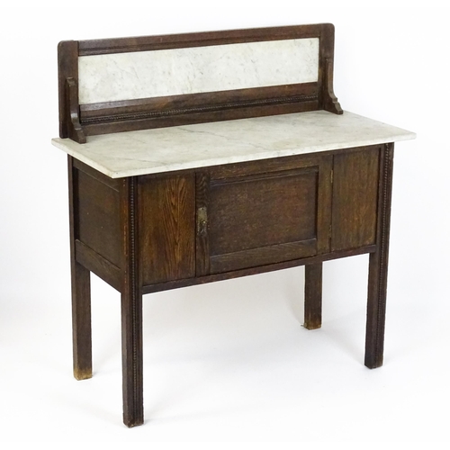 1501 - An early 20thC marble topped washstand with a raised splashback above single panelled door raised on... 