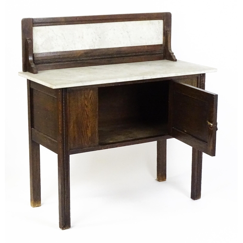 1501 - An early 20thC marble topped washstand with a raised splashback above single panelled door raised on... 