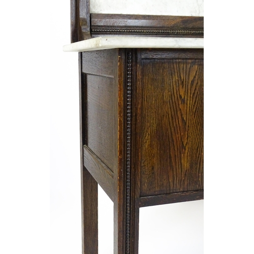 1501 - An early 20thC marble topped washstand with a raised splashback above single panelled door raised on... 