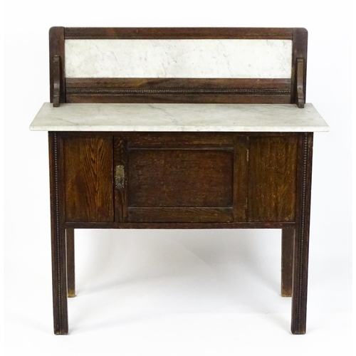 1501 - An early 20thC marble topped washstand with a raised splashback above single panelled door raised on... 