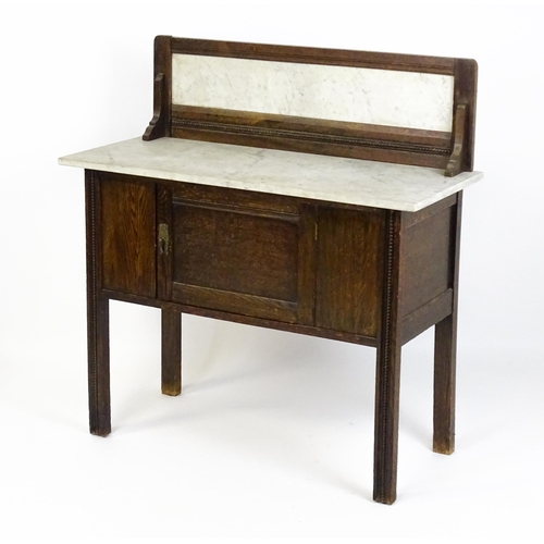 1501 - An early 20thC marble topped washstand with a raised splashback above single panelled door raised on... 