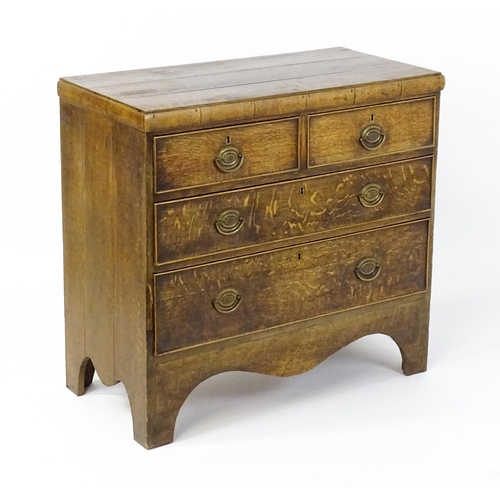 1502 - A late Georgian oak chest of drawers comprising a planked top above two short over two long drawers ... 