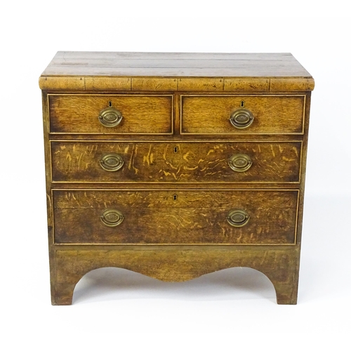 1502 - A late Georgian oak chest of drawers comprising a planked top above two short over two long drawers ... 