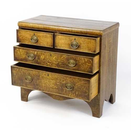 1502 - A late Georgian oak chest of drawers comprising a planked top above two short over two long drawers ... 