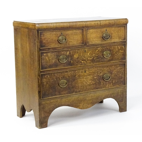 1502 - A late Georgian oak chest of drawers comprising a planked top above two short over two long drawers ... 