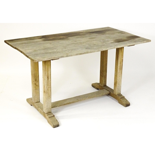 1506 - An early 20thC Heals style oak trestle table with a planked top. 54