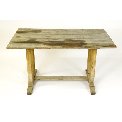 1506 - An early 20thC Heals style oak trestle table with a planked top. 54