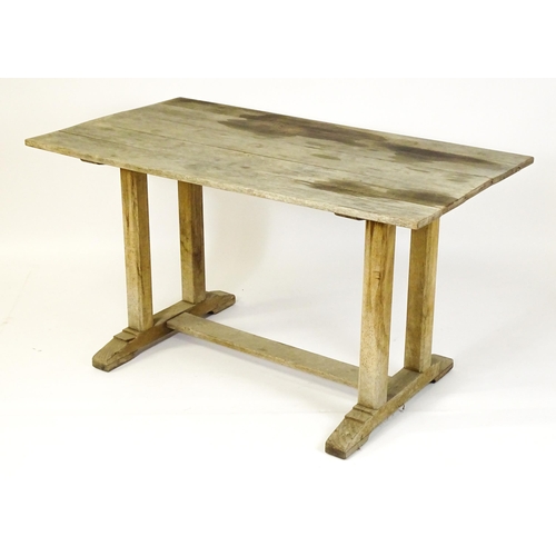 1506 - An early 20thC Heals style oak trestle table with a planked top. 54