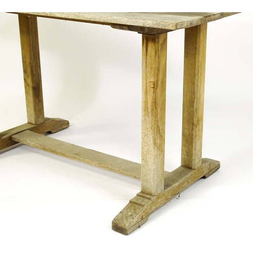 1506 - An early 20thC Heals style oak trestle table with a planked top. 54