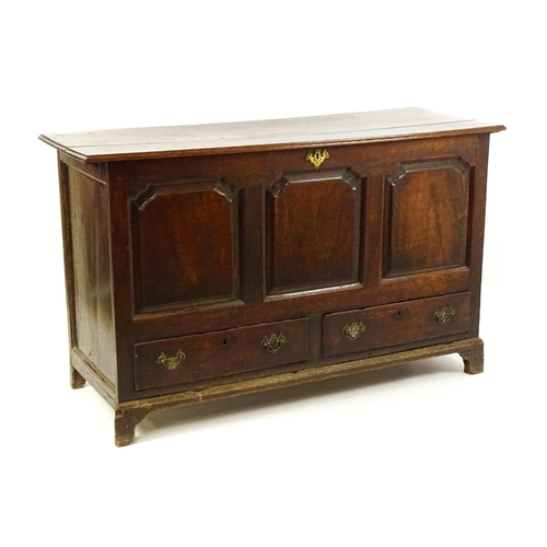 1526 - A George II mule chest with a hinged lid above a triple panelled front and two short drawers raised ... 