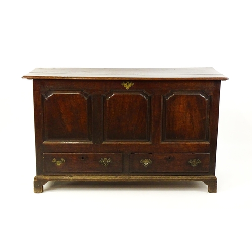 1526 - A George II mule chest with a hinged lid above a triple panelled front and two short drawers raised ... 