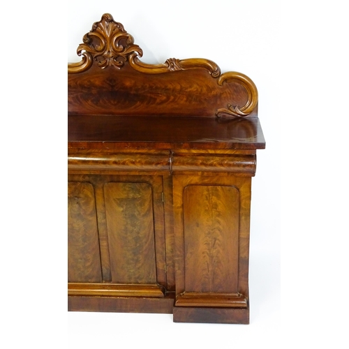 1528 - A 19thC mahogany sideboard with a carved, shaped upstand above three short drawers, the  pedestal ba... 