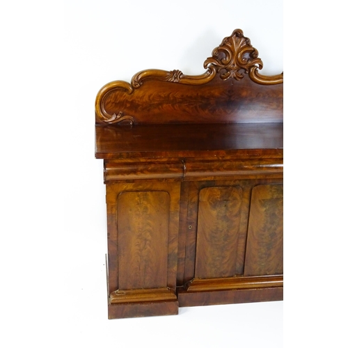 1528 - A 19thC mahogany sideboard with a carved, shaped upstand above three short drawers, the  pedestal ba... 