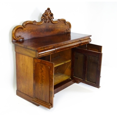 1528 - A 19thC mahogany sideboard with a carved, shaped upstand above three short drawers, the  pedestal ba... 