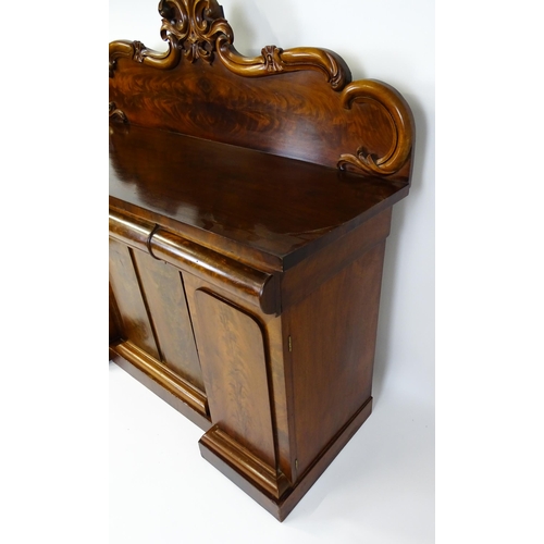 1528 - A 19thC mahogany sideboard with a carved, shaped upstand above three short drawers, the  pedestal ba... 