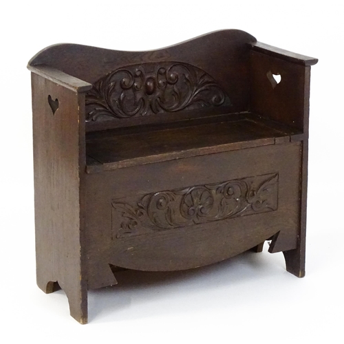 1529 - An early 20thC oak monks bench with pierced heart shaped decoration, having a carved backrest and ap... 