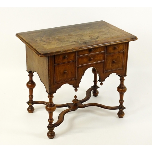 1536 - A late 17thC / early 18thC walnut lowboy with a crossbanded top above six small drawers raised on tu... 