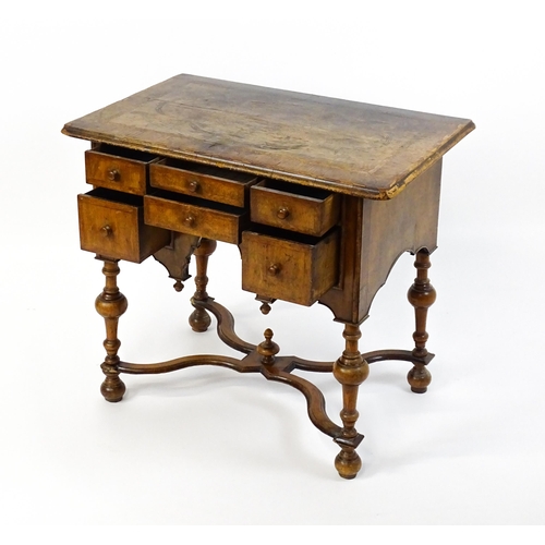 1536 - A late 17thC / early 18thC walnut lowboy with a crossbanded top above six small drawers raised on tu... 