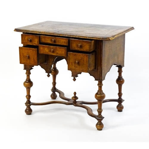 1536 - A late 17thC / early 18thC walnut lowboy with a crossbanded top above six small drawers raised on tu... 