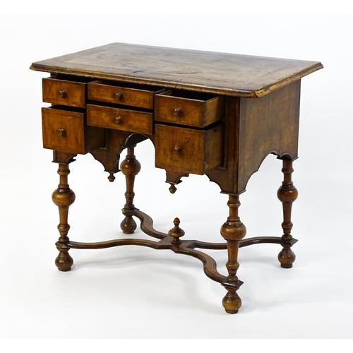 1536 - A late 17thC / early 18thC walnut lowboy with a crossbanded top above six small drawers raised on tu... 