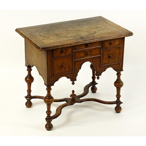 1536 - A late 17thC / early 18thC walnut lowboy with a crossbanded top above six small drawers raised on tu... 