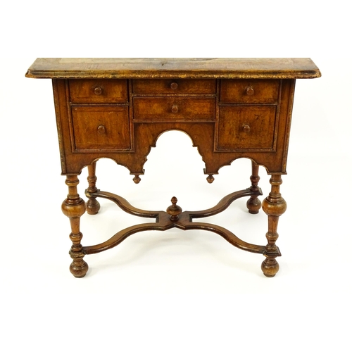 1536 - A late 17thC / early 18thC walnut lowboy with a crossbanded top above six small drawers raised on tu... 