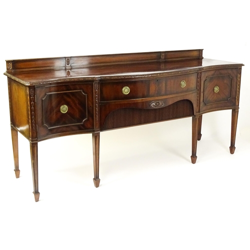 1537 - A Waring and Gillows mahogany sideboard with a floral carved upstand above a moulded edge and two pa... 