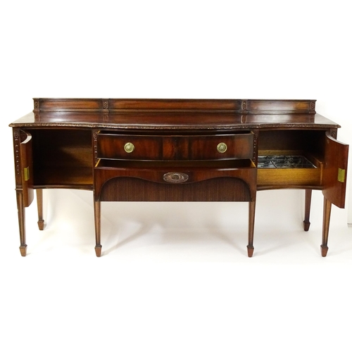 1537 - A Waring and Gillows mahogany sideboard with a floral carved upstand above a moulded edge and two pa... 