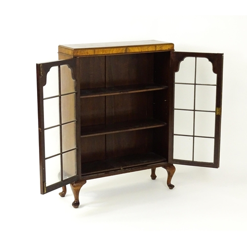 1545 - An early / mid 20thC walnut glazed display cabinet with two astragal glazed doors raised on four cab... 