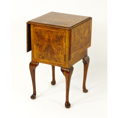 1548 - An early 20thC walnut bedside cabinet / pot cupboard with a crossbanded top having two drop leaves a... 