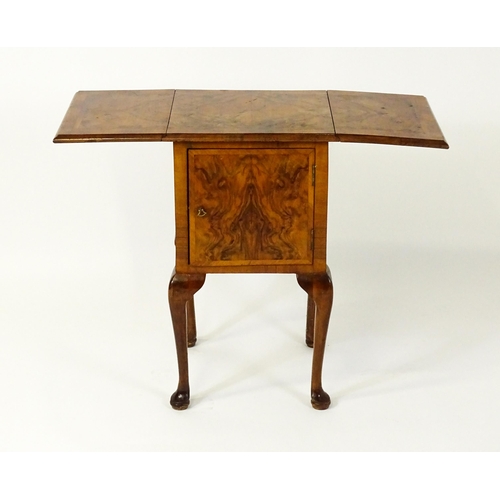 1548 - An early 20thC walnut bedside cabinet / pot cupboard with a crossbanded top having two drop leaves a... 