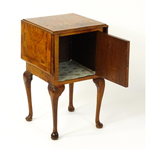 1548 - An early 20thC walnut bedside cabinet / pot cupboard with a crossbanded top having two drop leaves a... 