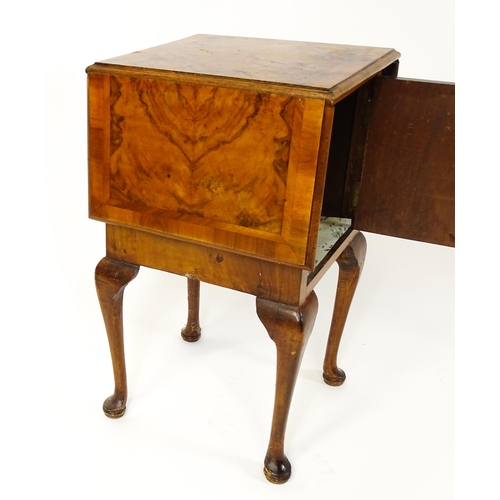 1548 - An early 20thC walnut bedside cabinet / pot cupboard with a crossbanded top having two drop leaves a... 