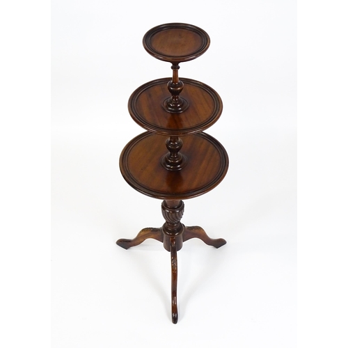 1550 - A 20thC three tier mahogany dumb waiter , with three graduated tiers above a turned pedestal with tw... 