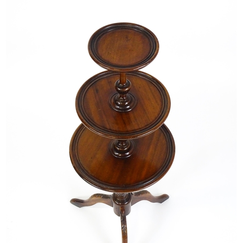 1550 - A 20thC three tier mahogany dumb waiter , with three graduated tiers above a turned pedestal with tw... 