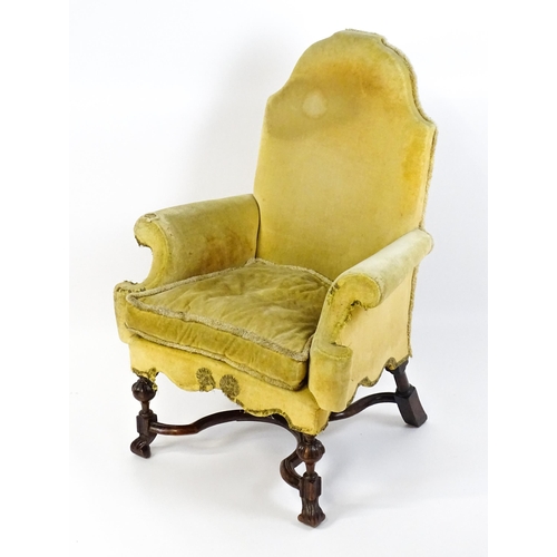 1556 - A 19thC William and Mary style armchair with a shaped backrest, scrolled arms raised on carved front... 