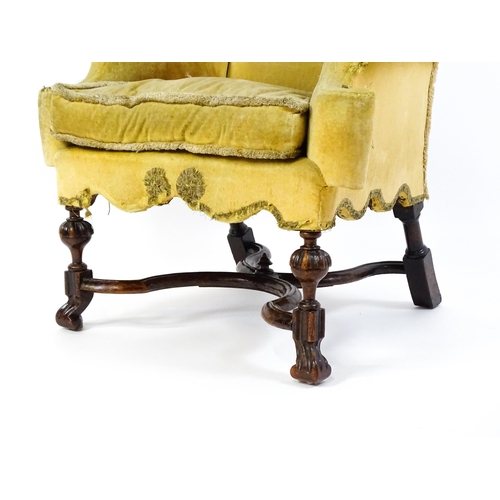 1556 - A 19thC William and Mary style armchair with a shaped backrest, scrolled arms raised on carved front... 