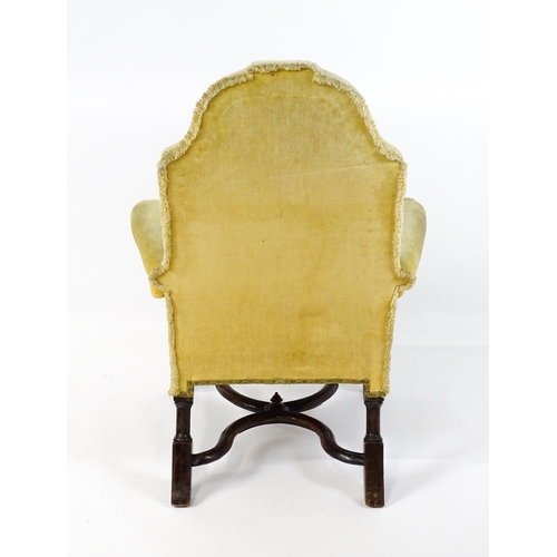 1556 - A 19thC William and Mary style armchair with a shaped backrest, scrolled arms raised on carved front... 