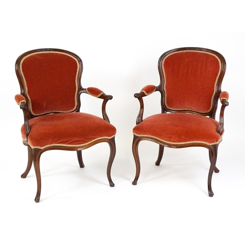 1567 - A pair of 19thC fauteuil armchairs with a carved cresting rail and arms raised on shaped seat rails ... 