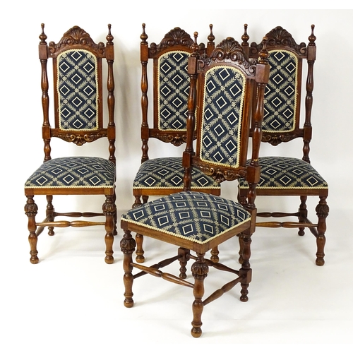 1579 - A set of four early 20thC dining chairs with carved cresting rails and surmounted by turned finials,... 