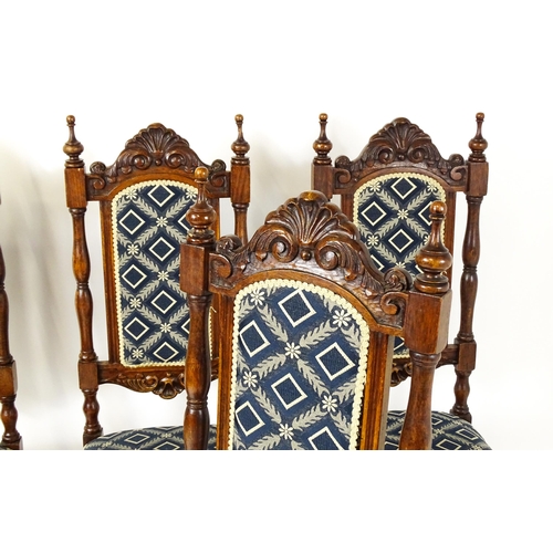 1579 - A set of four early 20thC dining chairs with carved cresting rails and surmounted by turned finials,... 