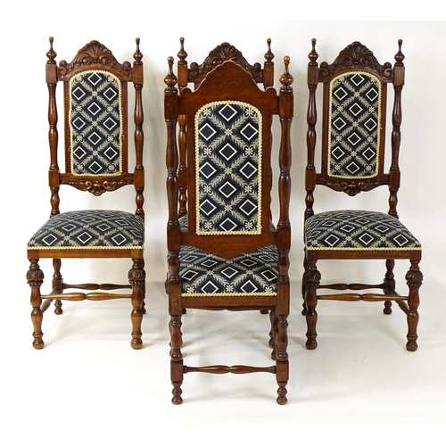 1579 - A set of four early 20thC dining chairs with carved cresting rails and surmounted by turned finials,... 