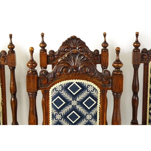 1579 - A set of four early 20thC dining chairs with carved cresting rails and surmounted by turned finials,... 