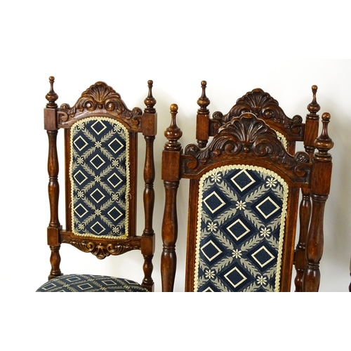 1579 - A set of four early 20thC dining chairs with carved cresting rails and surmounted by turned finials,... 