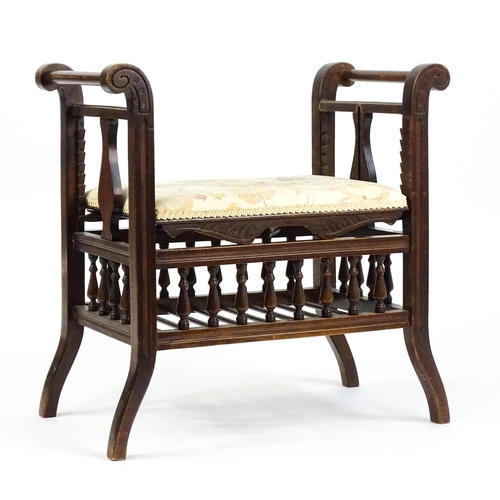 1622 - An Edwardian piano stool with scrolled uprights and vase shaped supports above an adjustable seat an... 