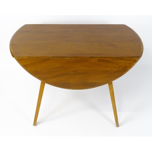 1631 - Vintage / Retro: An elm Ercol drop flap table with two demi lune leaves raised on four tapering legs... 