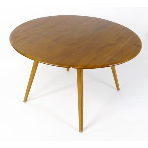 1631 - Vintage / Retro: An elm Ercol drop flap table with two demi lune leaves raised on four tapering legs... 