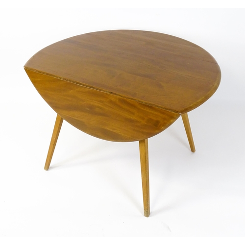 1631 - Vintage / Retro: An elm Ercol drop flap table with two demi lune leaves raised on four tapering legs... 