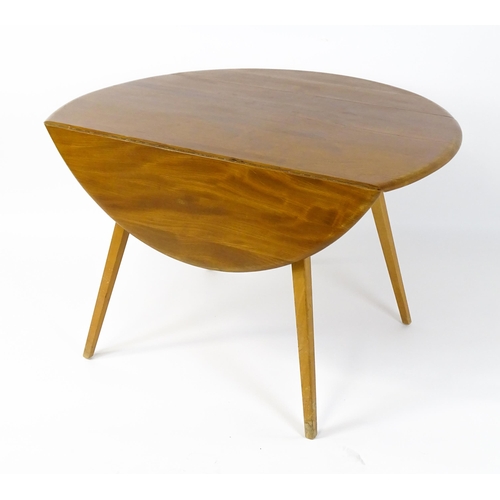 1631 - Vintage / Retro: An elm Ercol drop flap table with two demi lune leaves raised on four tapering legs... 