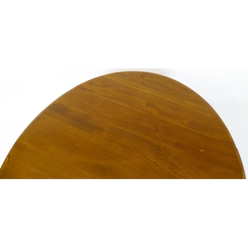 1631 - Vintage / Retro: An elm Ercol drop flap table with two demi lune leaves raised on four tapering legs... 